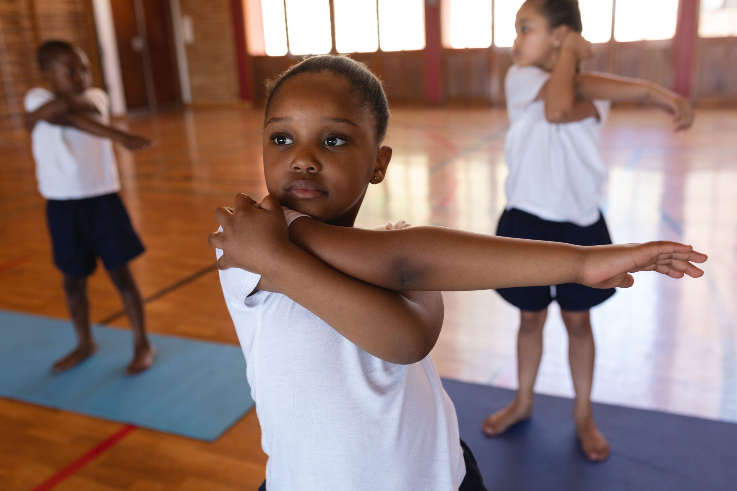 Capoeira para Niños: Diversión, Movimiento y Desarrollo Integral Niños practicando capoeira en la playa bajo la guía de un instructor.