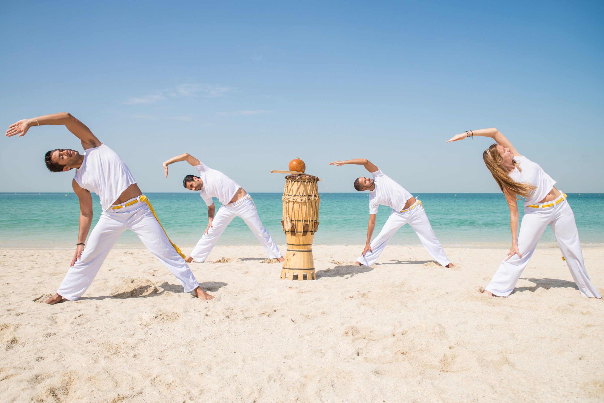 Calentamiento de Capoeira en la Playa: Energía y Conexión Grupo realizando un calentamiento de capoeira en la playa al amanecer.