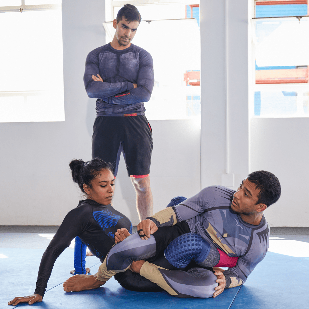 Instructor enseñando una llave de pierna durante una clase de grappling.