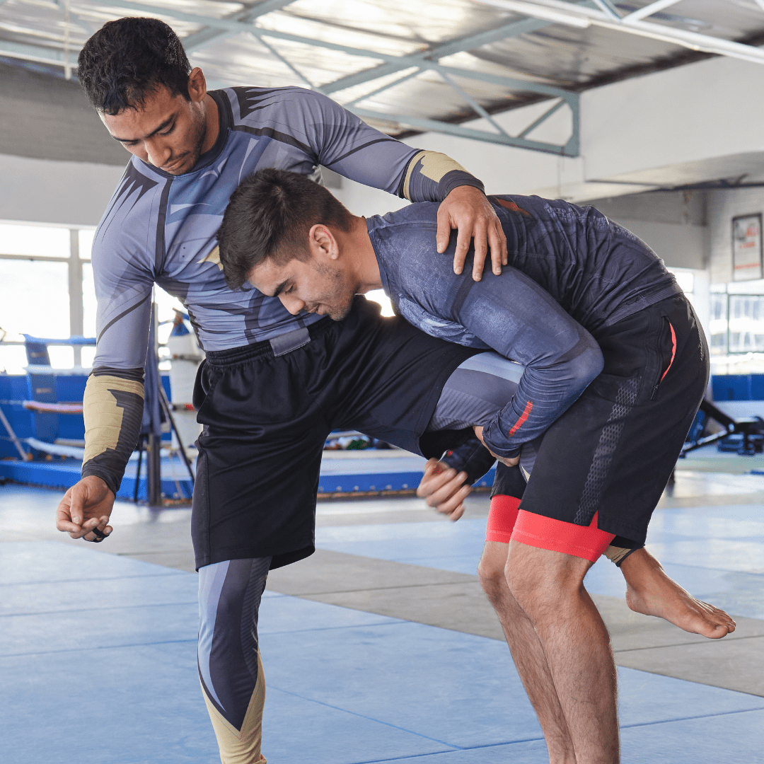 Atleta ejecutando un ataque de single leg durante el entrenamiento de grappling.