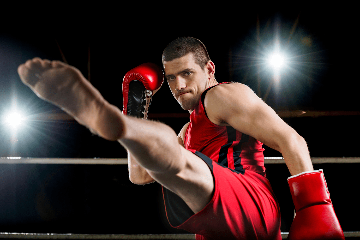 Crecimiento y Diversión en el Kickboxing Luchador de kickboxing ejecutando una patada alta durante el entrenamiento.