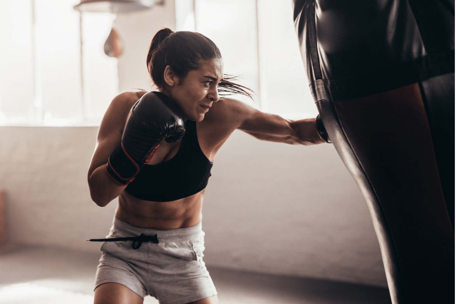 Mantente Activo y Saludable con Kickboxing Mujer entrenando kickboxing para mantenerse activa y en forma."