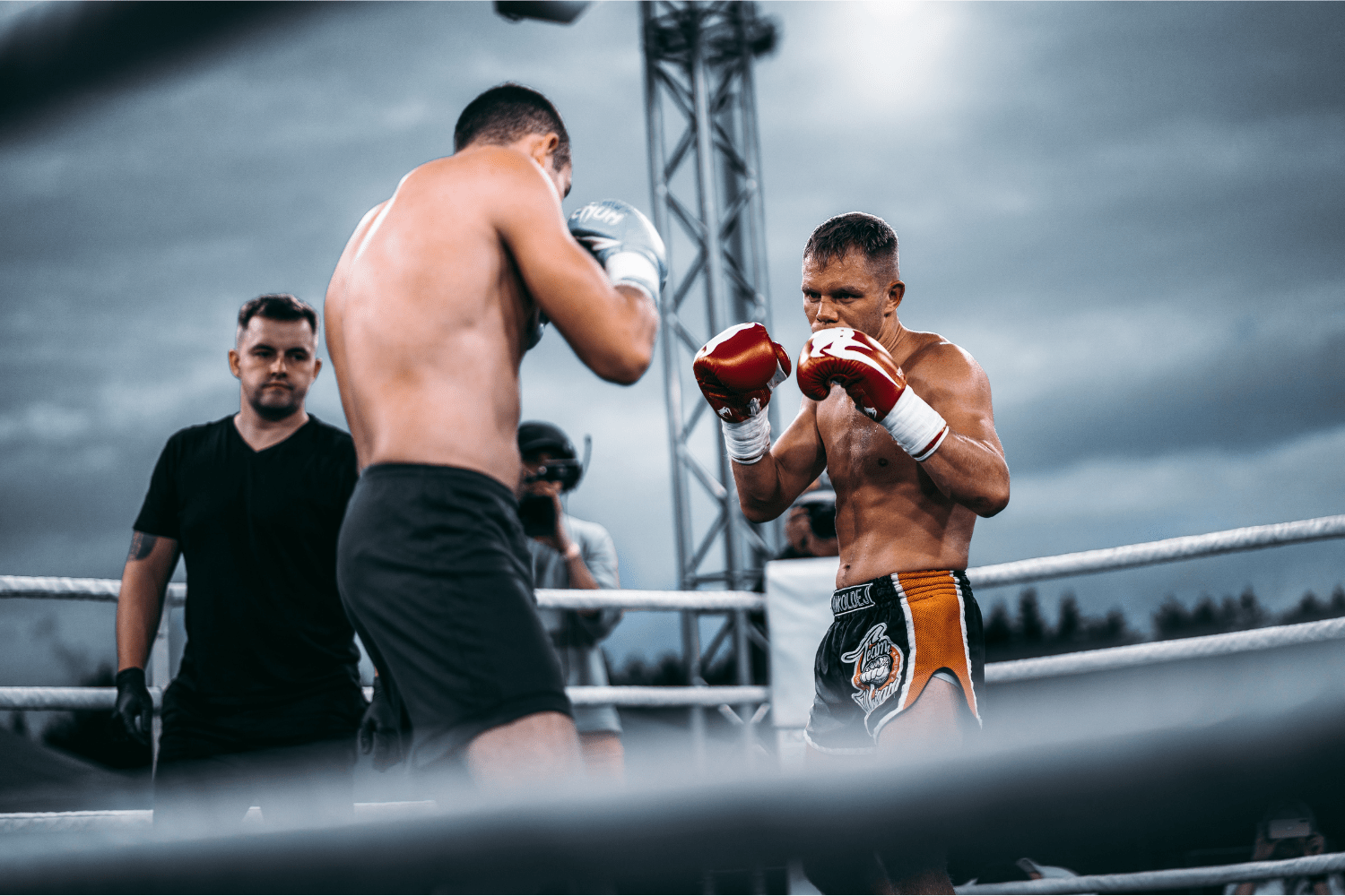 Potencia y Precisión en el Kickboxing Dos luchadores de kickboxing practicando técnicas con potencia y precisión en el ring.