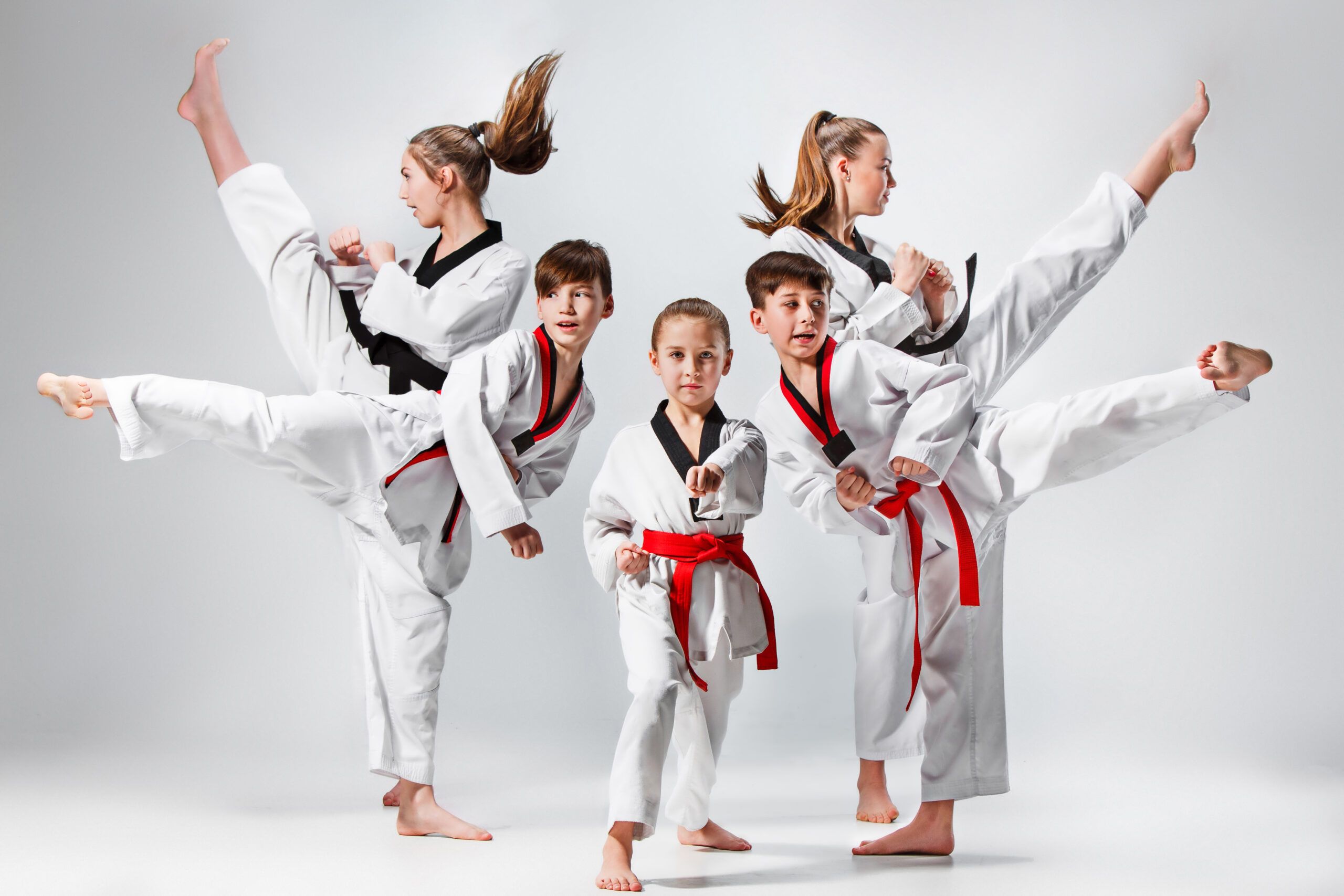 Niños en Formación: Taekwondo para el Crecimiento y la Diversión Niños en formación practicando patadas en una clase de taekwondo, combinando crecimiento personal y diversión.