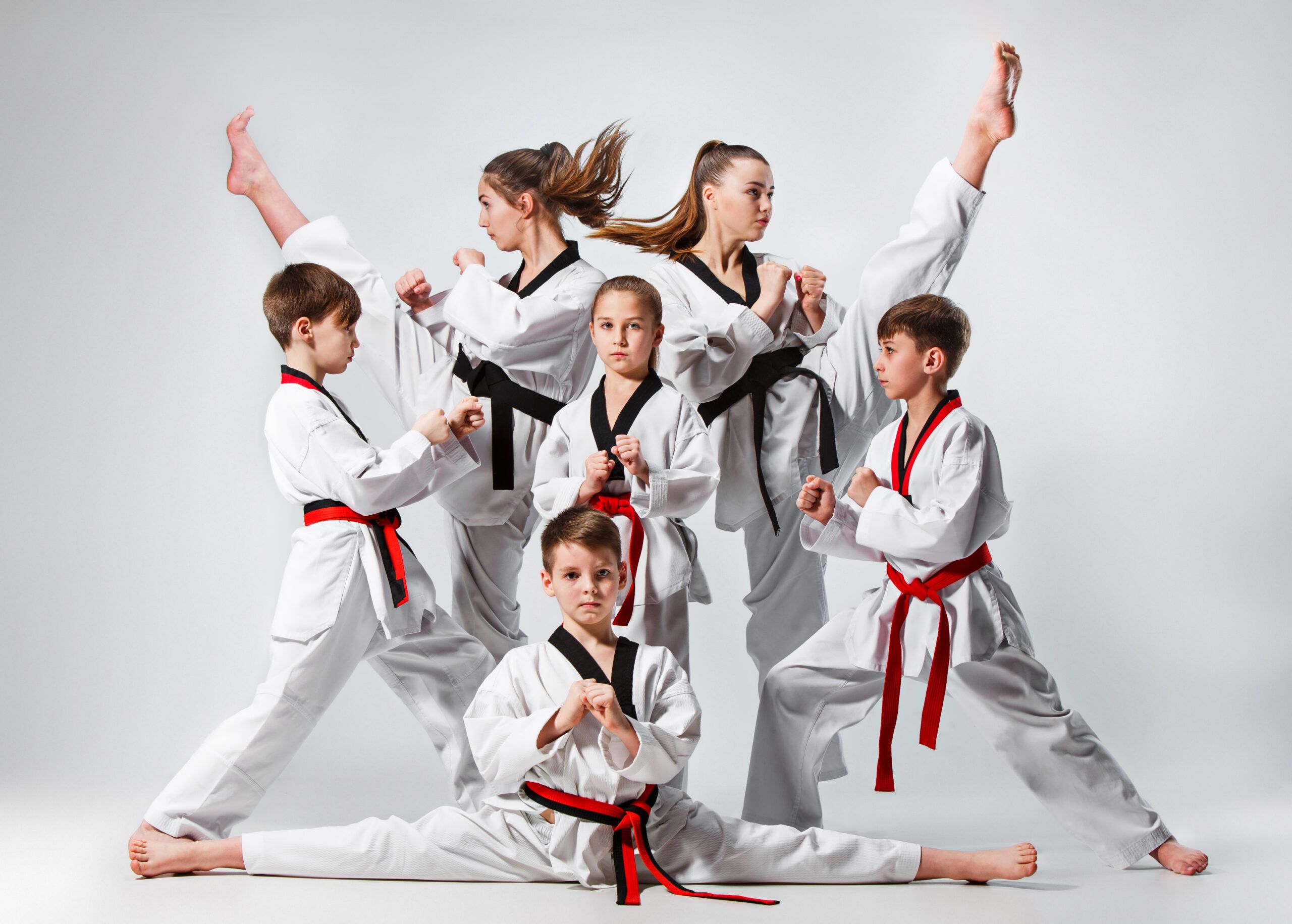 Clase de Taekwondo para Niños: Elasticidad, Patadas y Posición de Guardia Niños en grupo practicando taekwondo con posturas de elasticidad, patadas altas y posición de guardia.